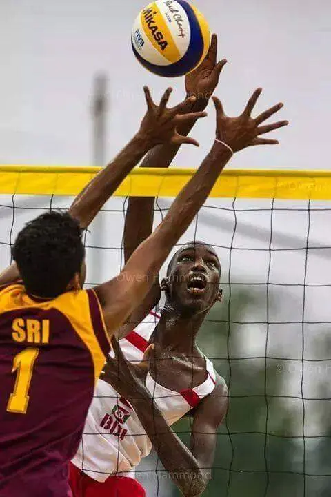 Isuru attacking at the net in beach volleyball