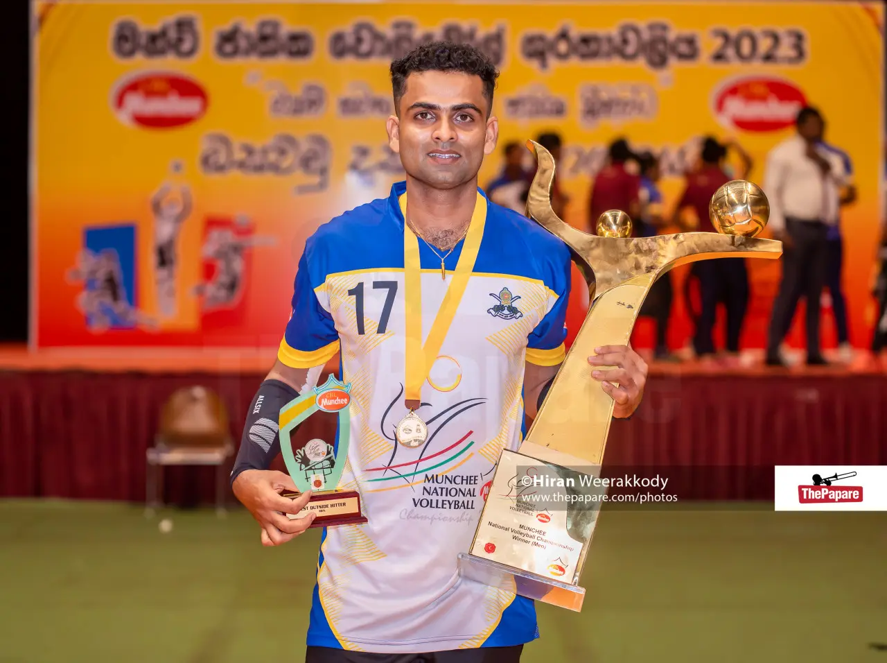 Isuru displaying trophies and a player award